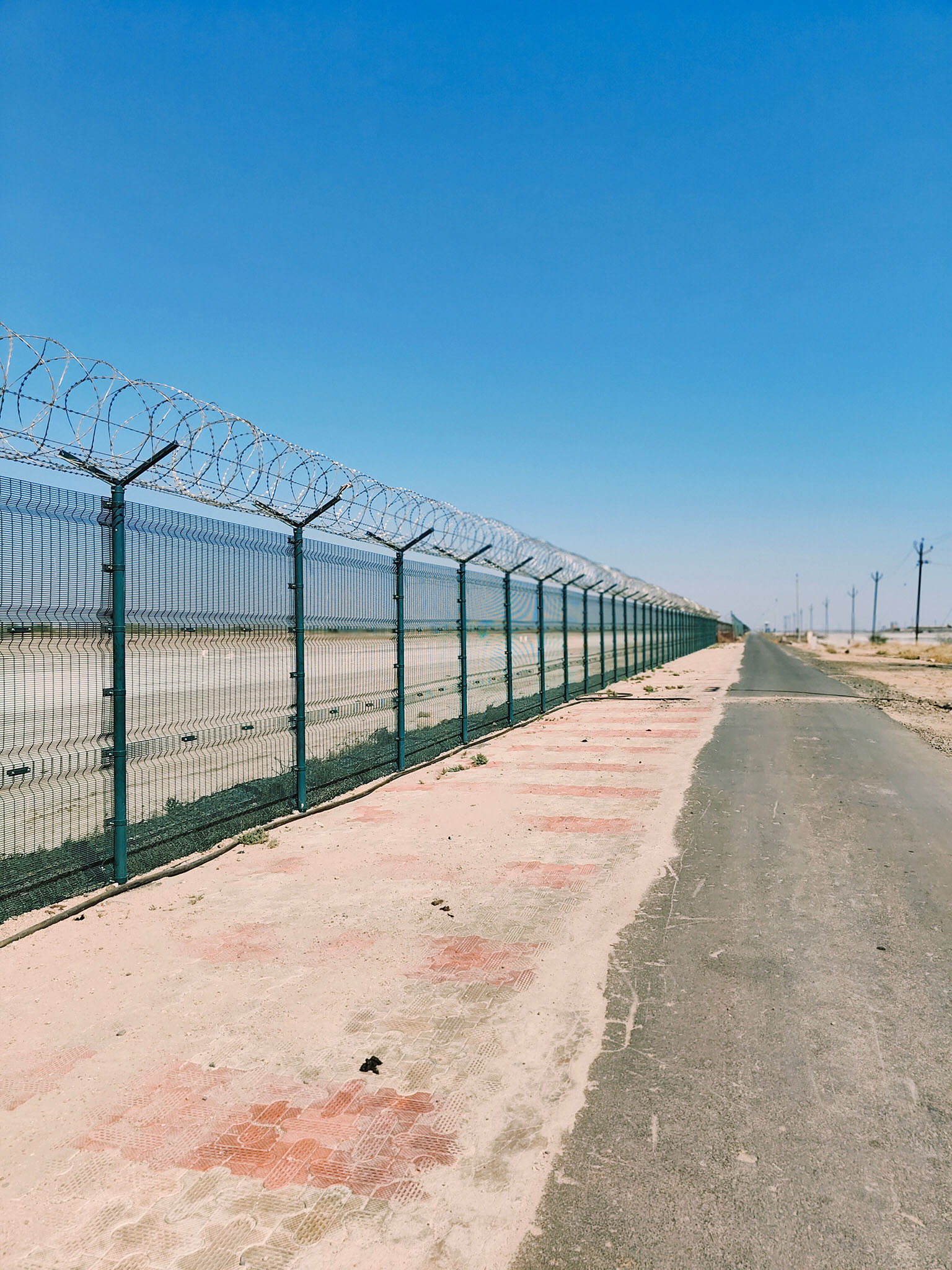 Border fence with barb wire in a desert area